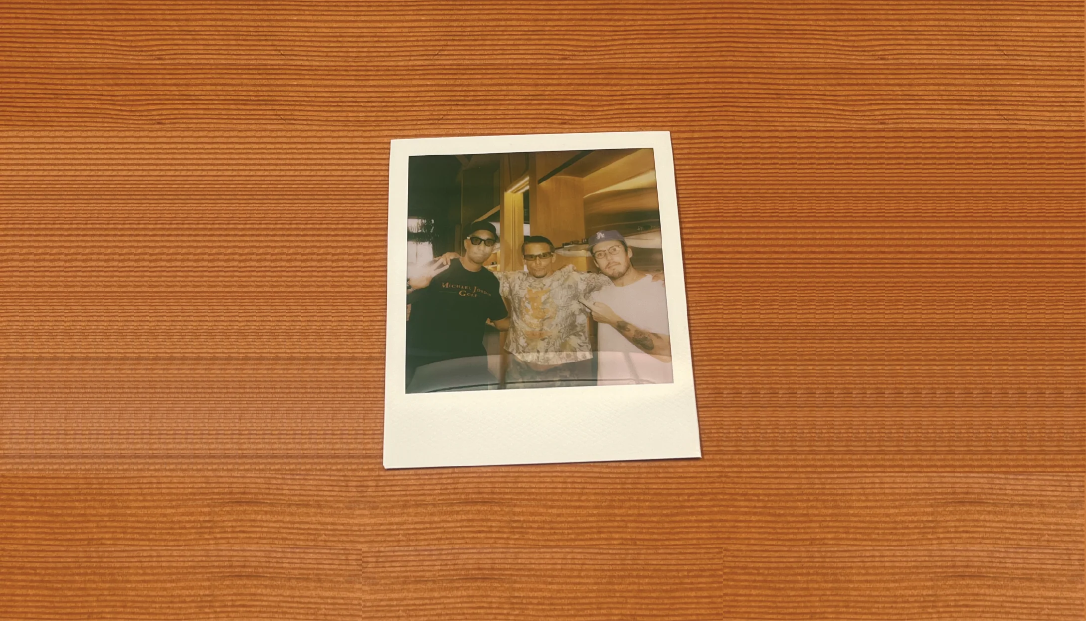 Polaroid photo of two people on a wooden surface